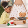 child playing with wooden cutting vegetable pieces