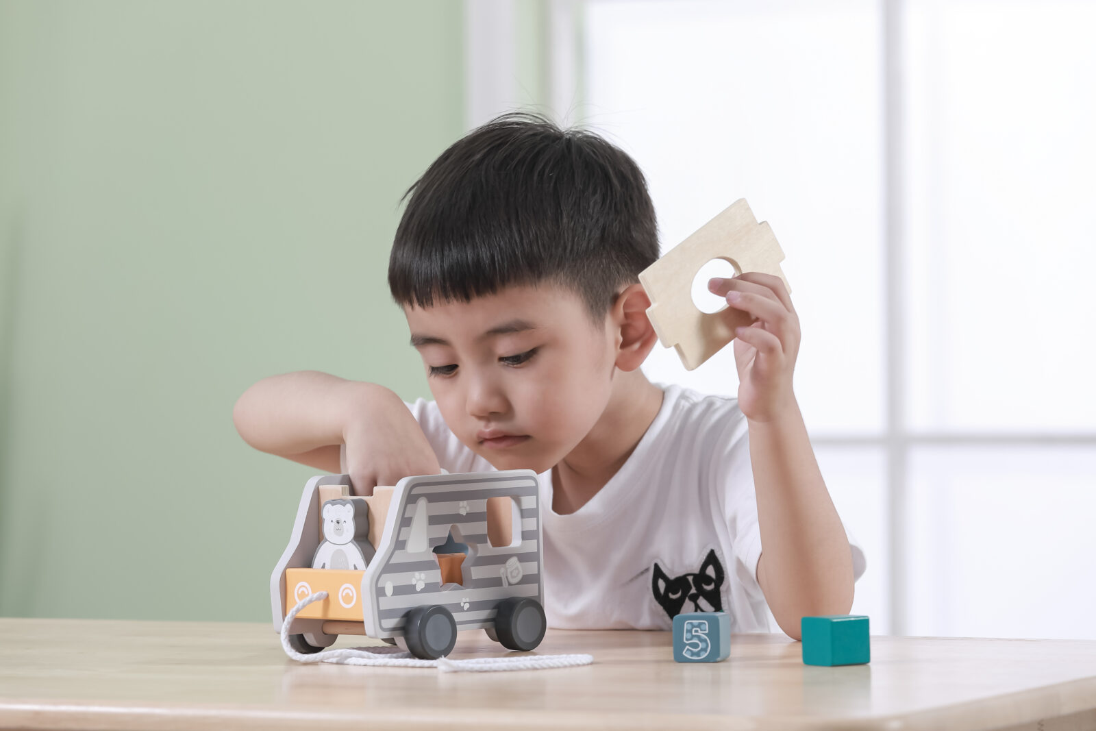 child lifting lid of shape sorter truck